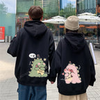 Matching couple hoodies with cartoon design featuring cute green and pink dinosaur prints on black hoodies