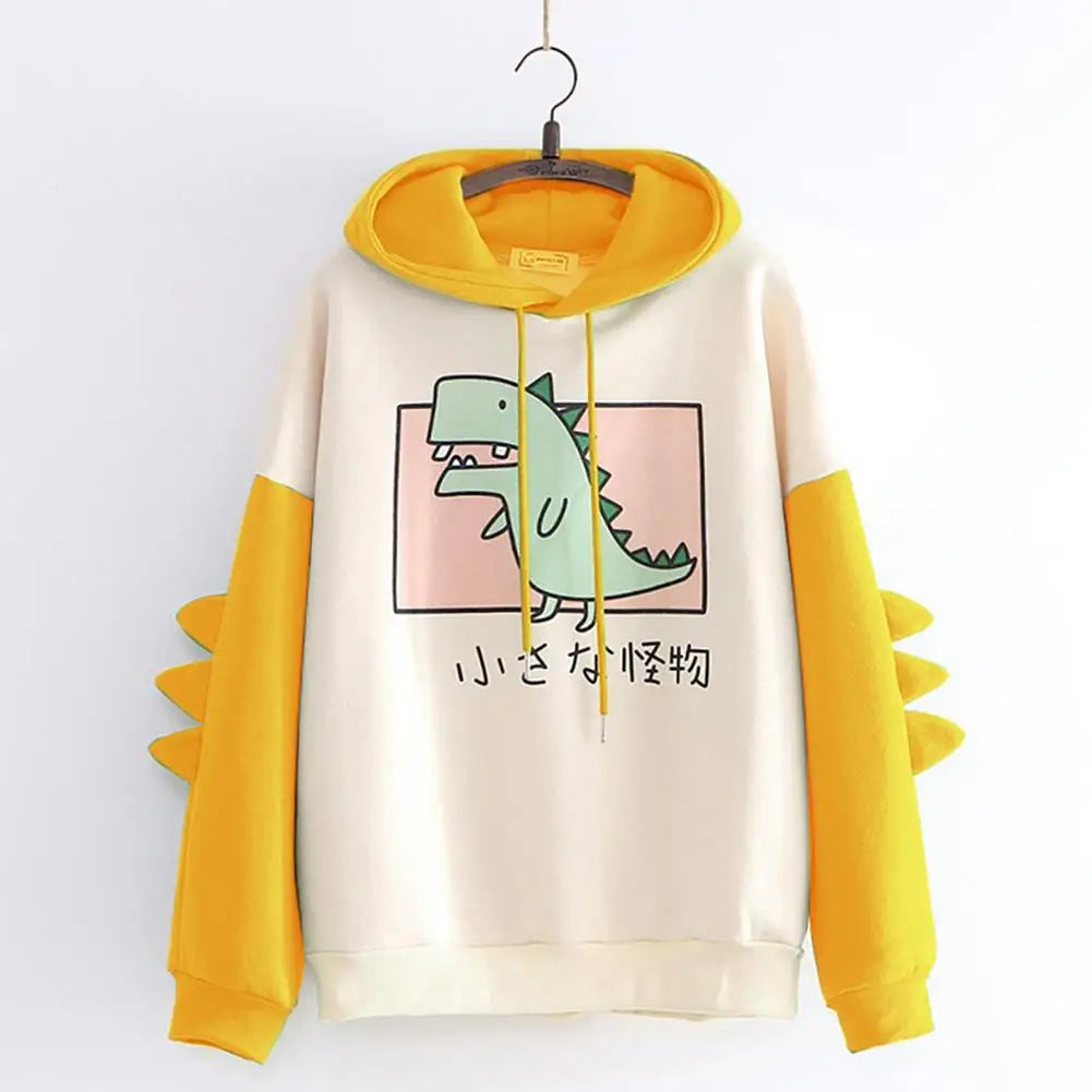 Kawaii dinosaur sweatshirt with yellow hood and sleeves featuring green dinosaur graphic and spikes on sleeves