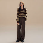 Woman wearing plus size casual spring sweater with brown and beige stripes paired with dark pants