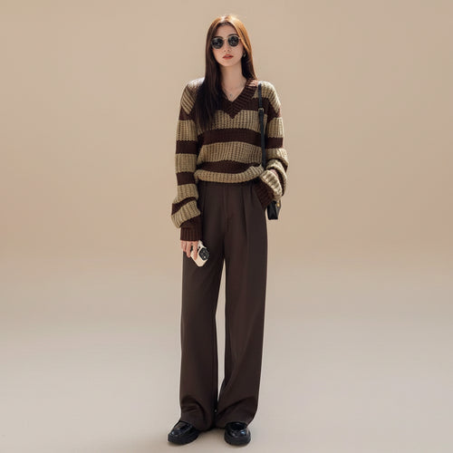 Woman wearing plus size casual spring sweater with brown and beige stripes paired with dark pants