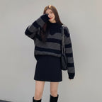 Plus size casual spring sweater with black and gray stripes worn with black skirt