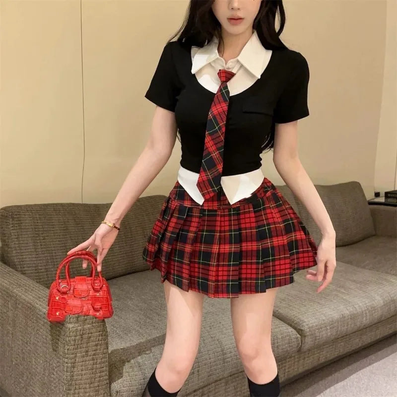 Woman wearing preppy style two piece skirt set with black top, white collar, red plaid skirt and tie holding a red handbag