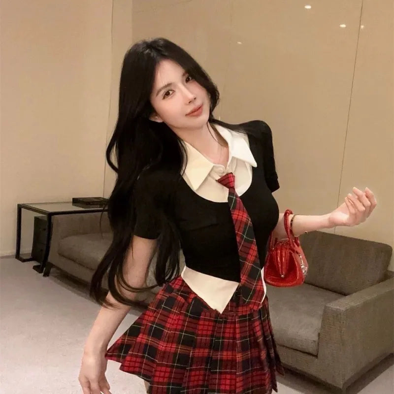 Woman wearing a preppy style two piece skirt set with black top and red plaid skirt indoors