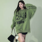 Cute green harajuku design hoodie worn by woman styled with black shorts and white boots