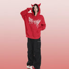 Trendy anime streetwear hoodie in red with cat ears and white graphic design worn by model