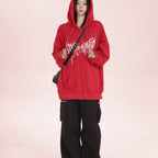Trendy anime streetwear hoodie in red with white graphic design worn with black cargo pants