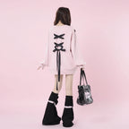 Back view of a girl wearing a pink sweet ribbon hoodie japanese style with black bows and black leg warmers