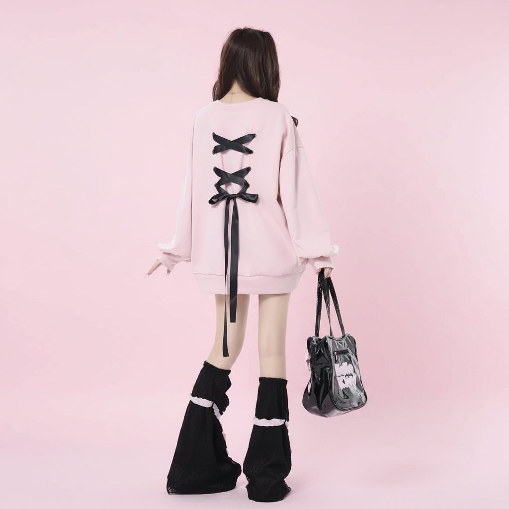 Back view of a girl wearing a pink sweet ribbon hoodie japanese style with black bows and black leg warmers