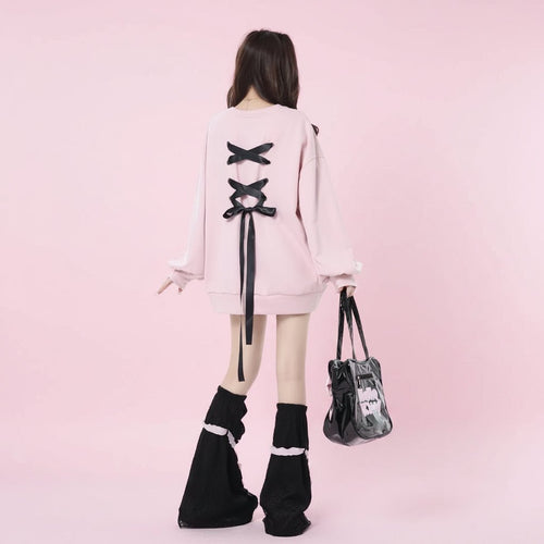 Back view of a girl wearing a pink sweet ribbon hoodie japanese style with black bows and black leg warmers
