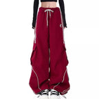 Red wide-leg pants from three piece streetwear set for women with white drawstring and black sneakers