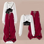 Three piece streetwear set for women with white cropped hoodie, black crop top, and maroon wide-leg pants