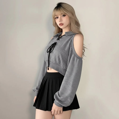 Woman wearing a cute Korean style streetwear top in gray with cold shoulder design and black skirt
