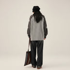 Back view of a woman wearing a double zipper autumn jacket for women with star-patterned sleeves and loose fit