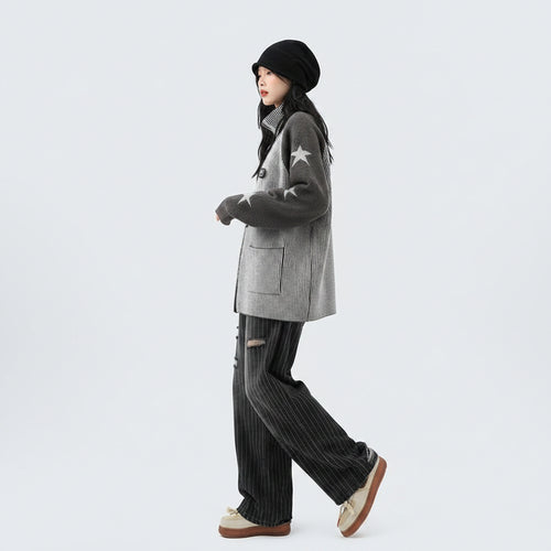 Woman wearing a double zipper autumn jacket for women with star patterns on sleeves paired with striped pants and beige shoes