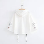 White Japanese soft girlcat style hoodie with cat paw and butterfly designs on sleeves hanging on hanger