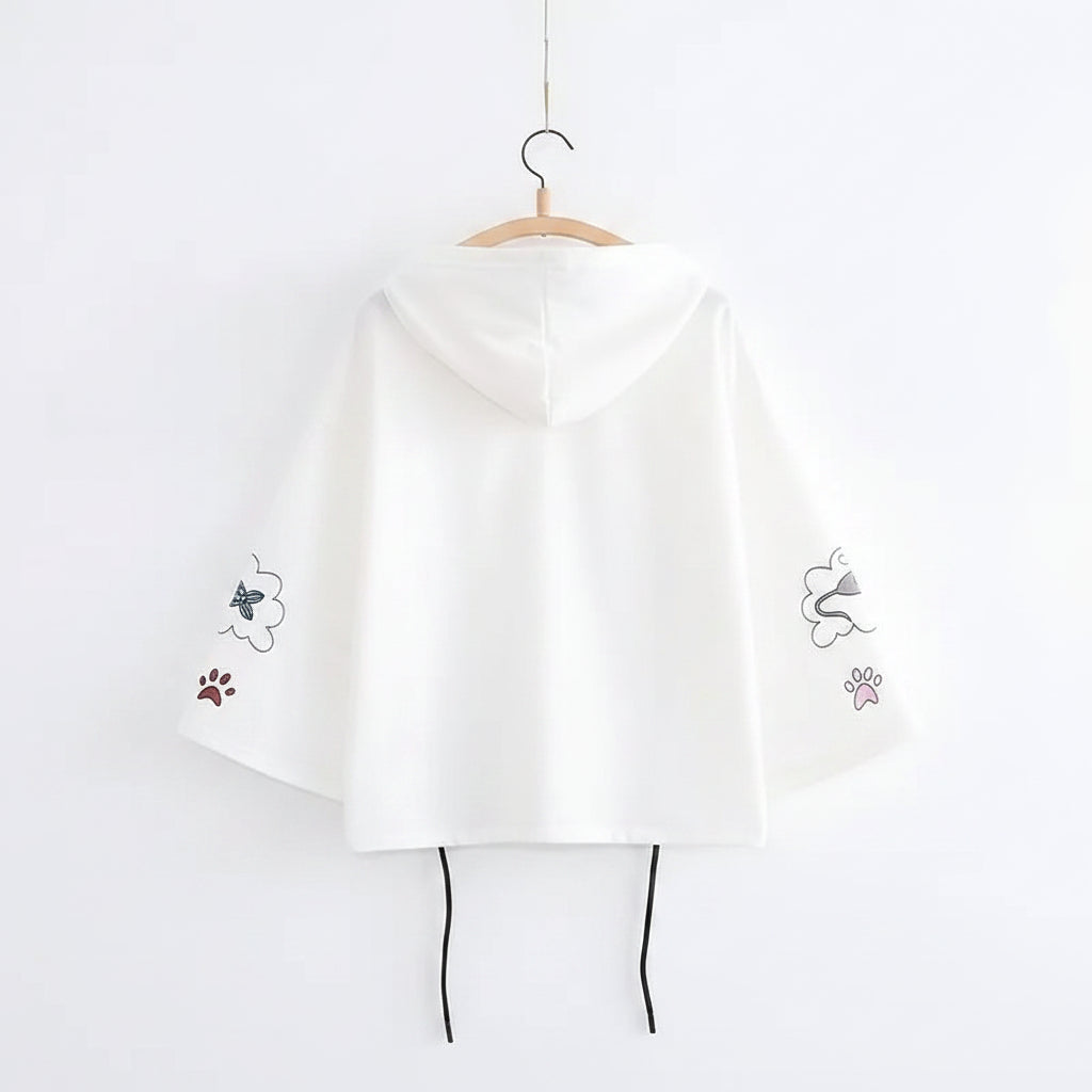 White Japanese soft girlcat style hoodie with cat paw and butterfly designs on sleeves hanging on hanger