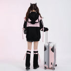 Woman wearing kawaii cat ear hoodie for women with ears in black and pink at the airport with suitcase