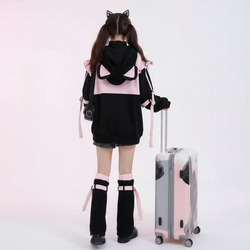 Woman wearing kawaii cat ear hoodie for women with ears in black and pink at the airport with suitcase