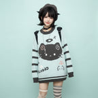 Woman wearing a pastel blue kawaii cat sweater for women with black cat face design and striped sleeves