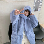 Woman wearing a cozy blue kawaii fluffy jacket for women with a hood and bear face details