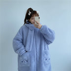 Woman wearing a light blue kawaii fluffy jacket for women with bear pocket details taking a selfie