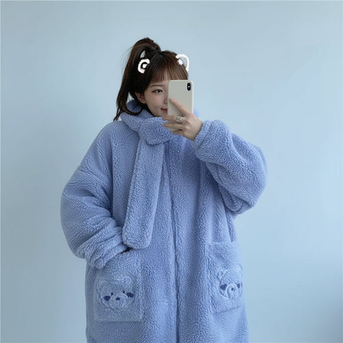 Woman wearing a light blue kawaii fluffy jacket for women with bear pocket details taking a selfie
