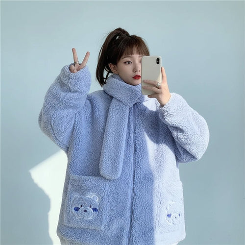 Woman wearing a light blue kawaii fluffy jacket for women with bear face pockets taking a mirror selfie