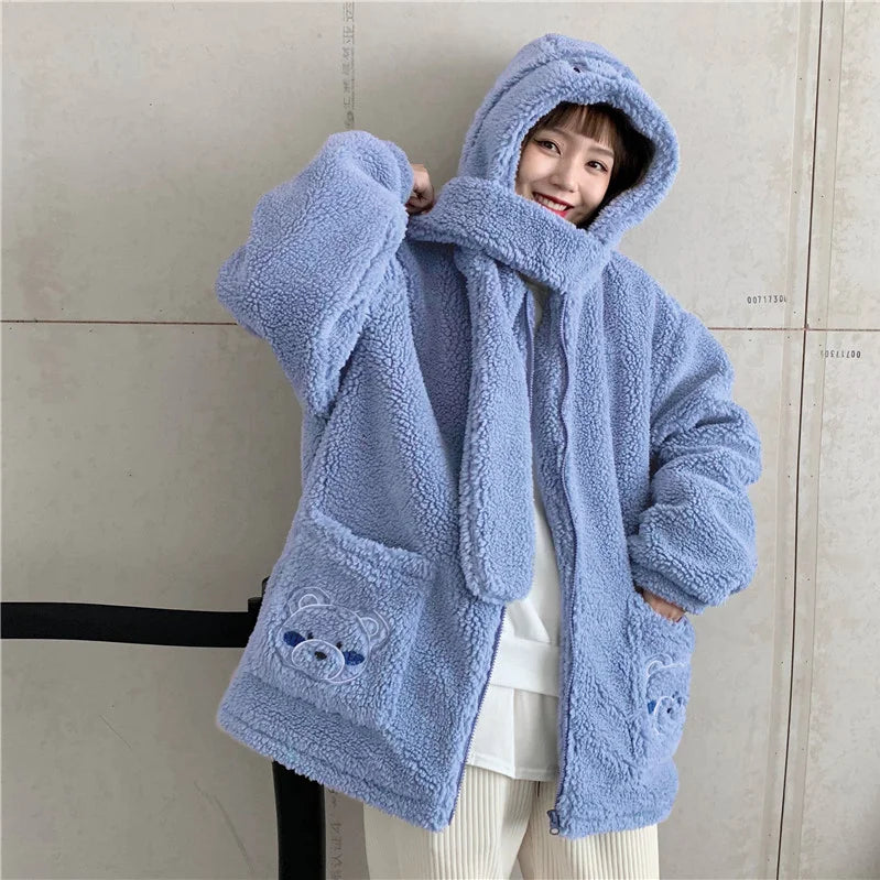 Woman wearing a blue kawaii fluffy jacket for women with hood and bear embroidery on pockets