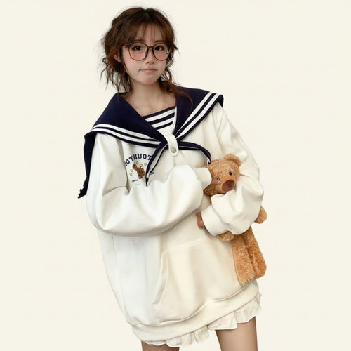 Woman wearing japanese harajuku bear oversized hoodie holding a teddy bear in a cozy room