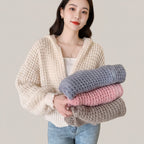 Vusy Kawaii Shop Official cream waffle knit zip-up hoodie with drawstring hood, worn by a person holding folded sweaters in blue, pink, and grey.