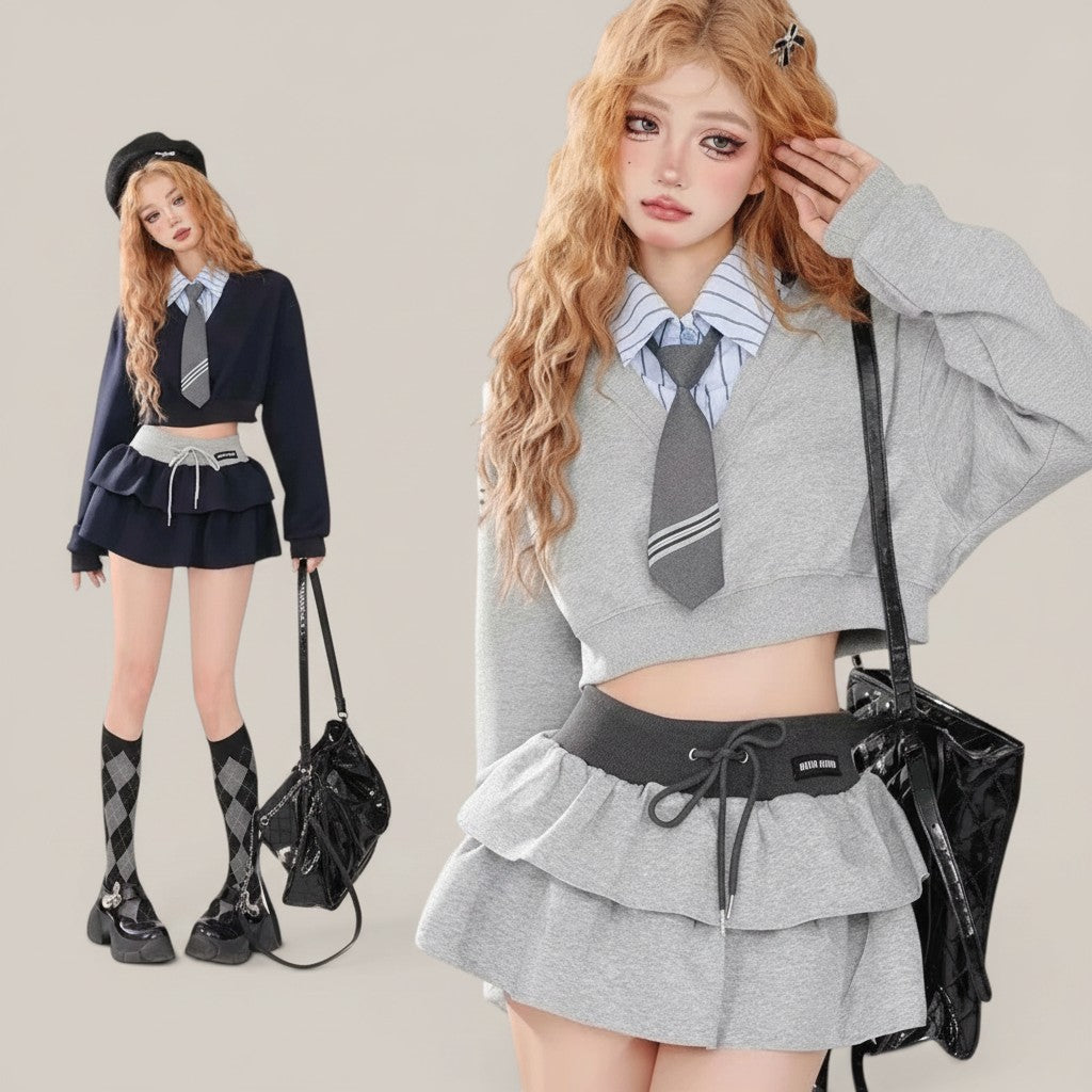 Vusy Kawaii Shop Official grey two-piece set with a cropped V-neck sweatshirt and tiered ruffle skirt, paired with a striped shirt and tie.