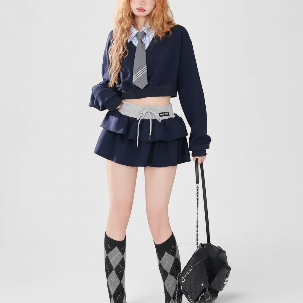 Vusy Kawaii Shop Official navy blue v-neck cropped sweatshirt with grey tie and layered skirt, styled with argyle socks.