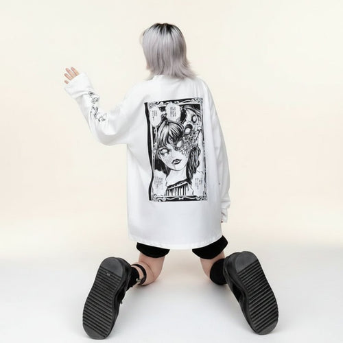 Women wearing white women's streetwear anime pullover with black graphic print kneeling on pavement