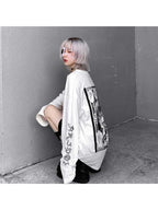 White women's streetwear anime pullover with black graphic print worn by a model with silver hair