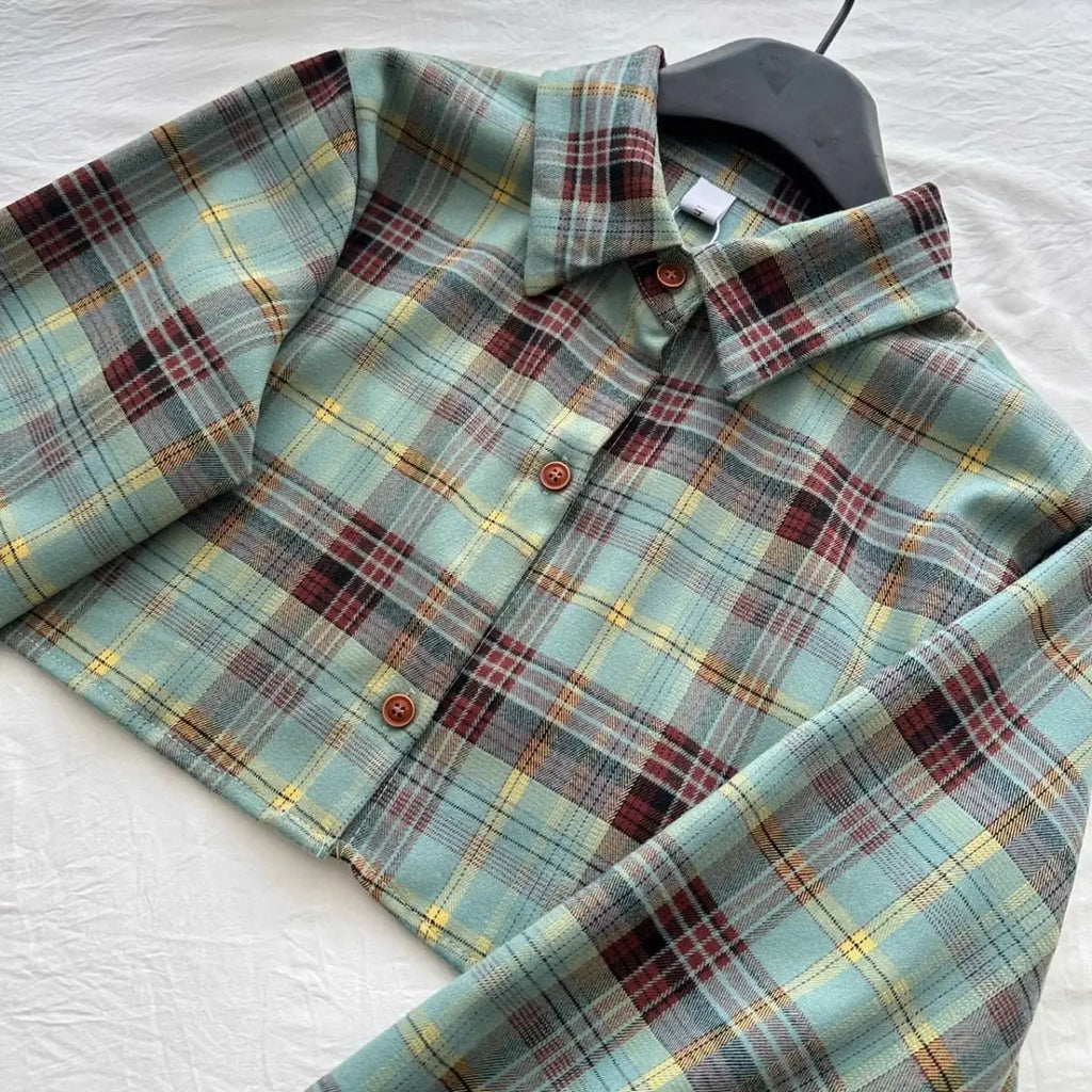 Plaid button-up shirt with green, yellow, and red pattern on black hanger from Vusy Kawai Shop