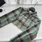 Plaid button-up cropped jacket with long sleeves laid flat on white fabric