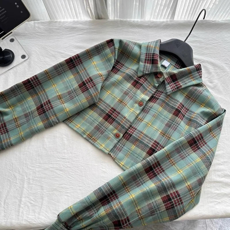 Plaid button-up cropped jacket with long sleeves laid flat on white fabric