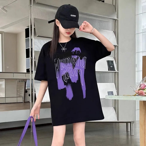 Woman modeling women's punk plaid skirt set with black oversized graphic t-shirt and black cap