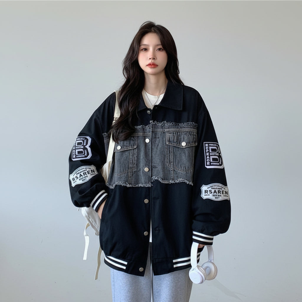 Women's retro denim baseball jacket with black sleeves and frayed chest pockets styled casually indoors