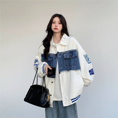 Women wearing women's retro denim baseball jacket with patch details and blue accents holding black handbag