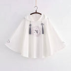 White women's spring autumn cute sweatshirt with wide sleeves and decorative tassels hanging on a wooden hanger