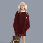 Cozy chunky knit cute style sweater women in burgundy worn with plaid skirt and fluffy earmuffs