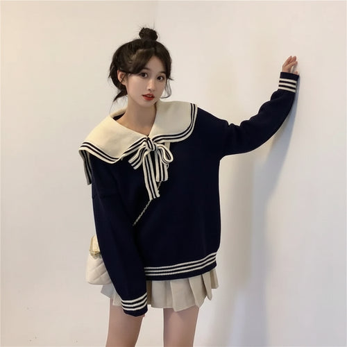 Woman wearing new trendy korean sweaters navy with white sailor collar and bow in cozy indoor setting