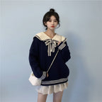 Woman wearing new trendy korean sweaters navy blue with white sailor collar and bow in a bedroom setting