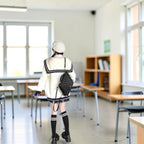 Woman wearing oversized knit cute sweater coat for women in white with navy details and black accessories indoors