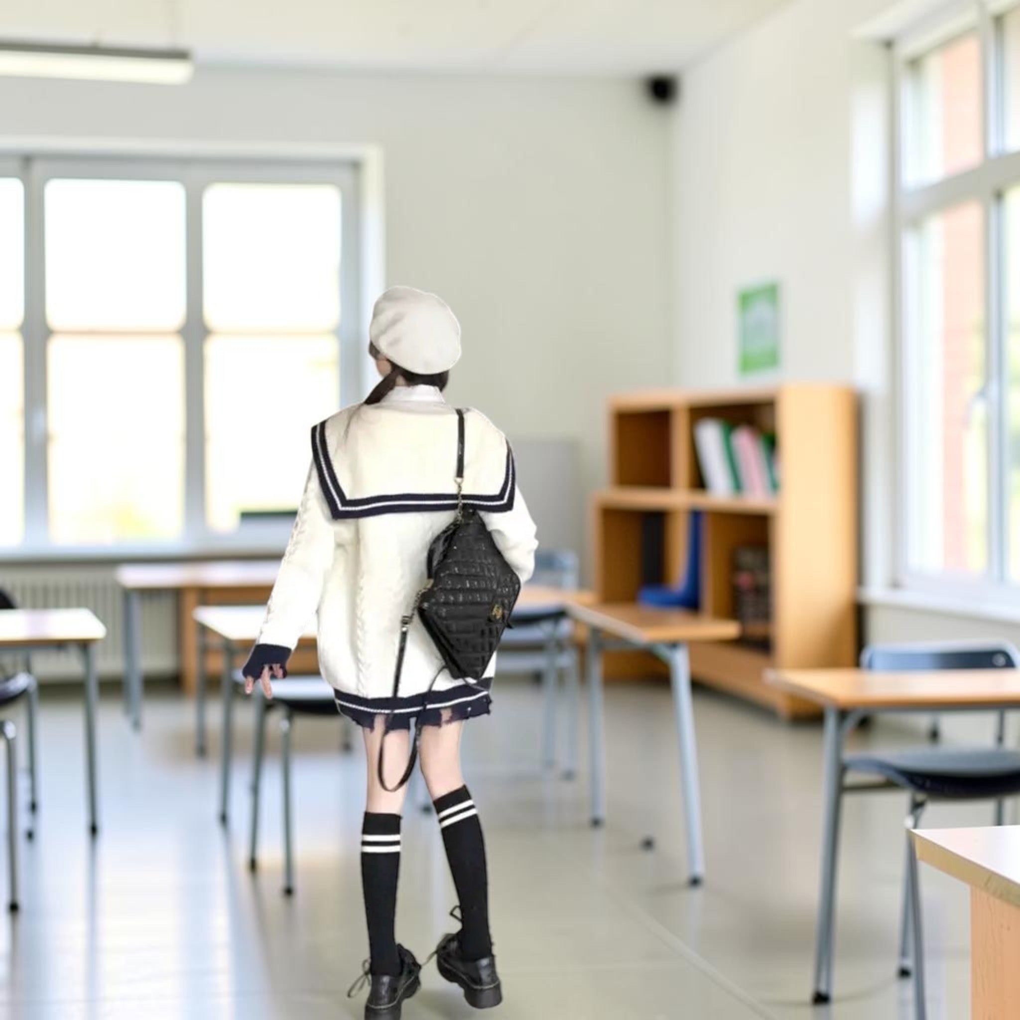 Woman wearing oversized knit cute sweater coat for women in white with navy details and black accessories indoors